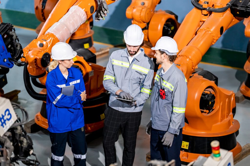 Engineer inspecting automatic AI robot arm and machines in factory. Engineer inspecting automatic AI